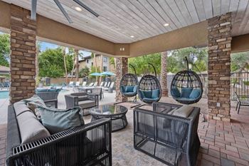 A patio with a black wicker couch and a table with a glass top. at The Laurel Apartments, Chandler, AZ 85286